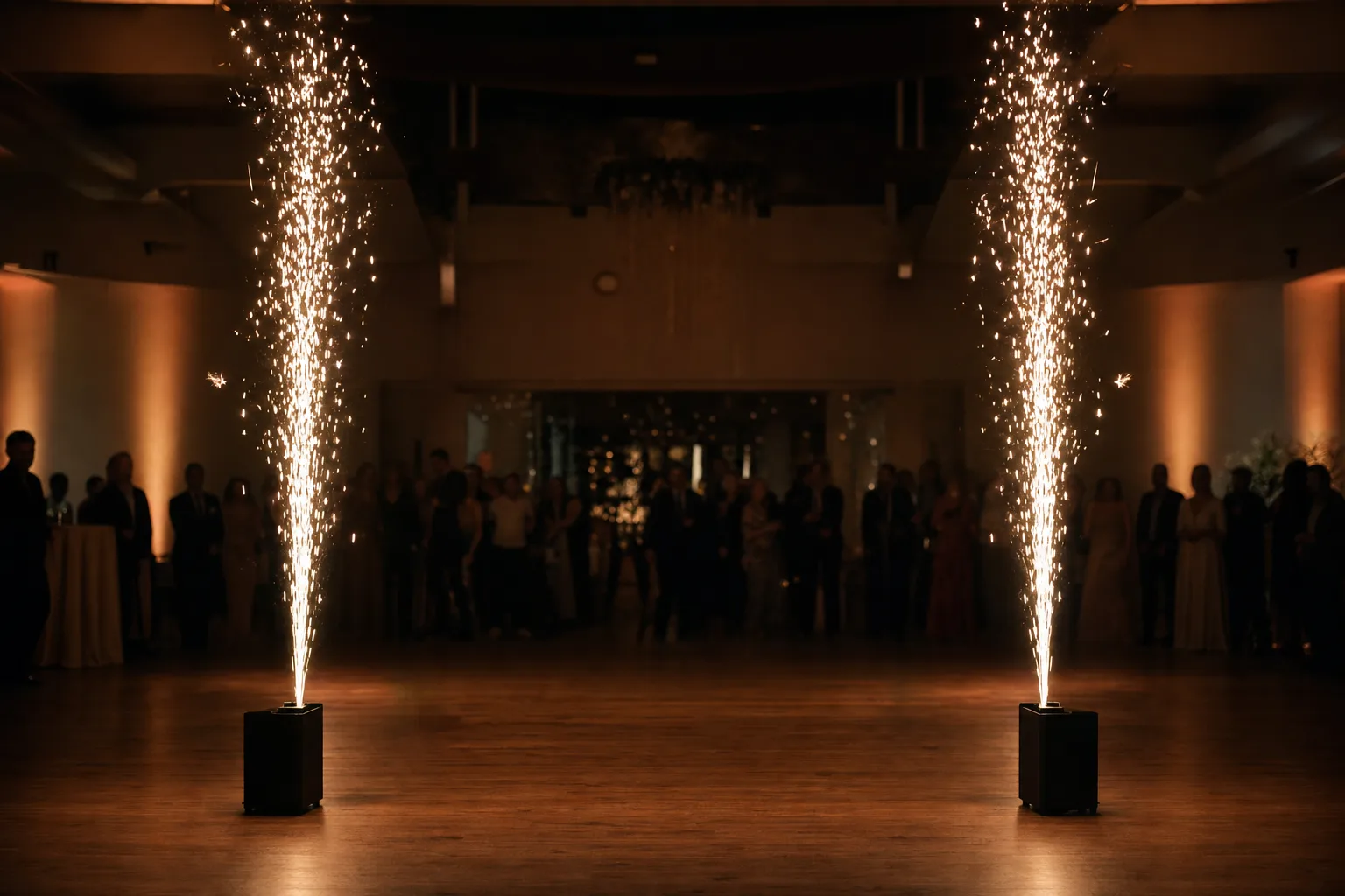 Illustration: two floor-standing cold spark fountains throwing golden sparks upward on either side of an indoor dance floor